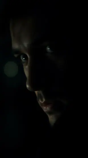 AI Video: Cinematic close-up of a mysterious noir man in a dim tavern,
soft...