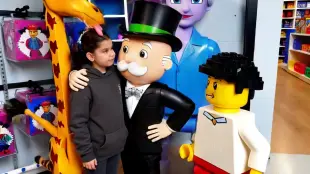 AI Video: The girl is licked on the head by the giraffe and hugged by the man in the...