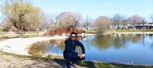 AI Video: A realistic wildlife scene in a forest with a wooden bridge behind a man....