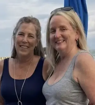 AI Video: Zoom in as the women make eye contact and then share a slow deep kiss