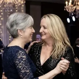 AI Video: Show the woman on the left licking the other woman’s larger breasts as they...