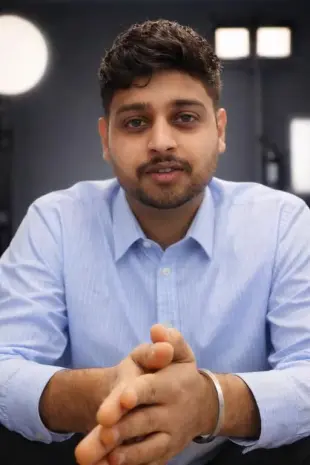 AI Video: professional young man sitting confidently in a studio environment, wearing a...