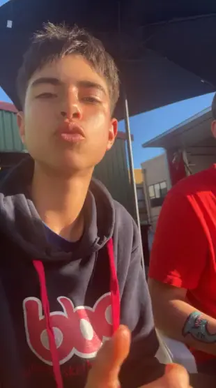 AI Video: Make him stand up and take both his hoodie and shirt off