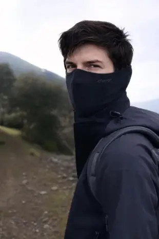 AI Video: Young man with mask is putting on ski helmet and ski googles, heavily breathing.