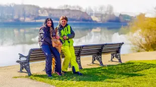 AI Video: Persons are happy toghether their dog. They smiling and touching dog who is...