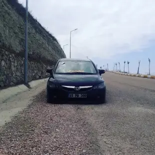 AI Video: Black Honda Civic with air suspension driving on a coastal mountain road,...