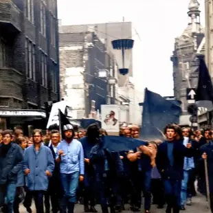 AI Video: Let this group march forward waving with their flags and signs.